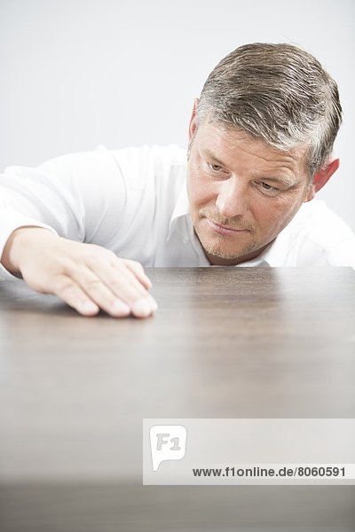 Man checking the surface of a wooden table