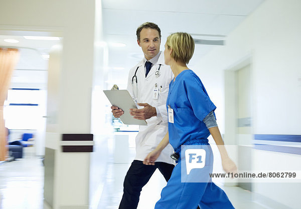 Doctor and nurse walking in hospital hallway