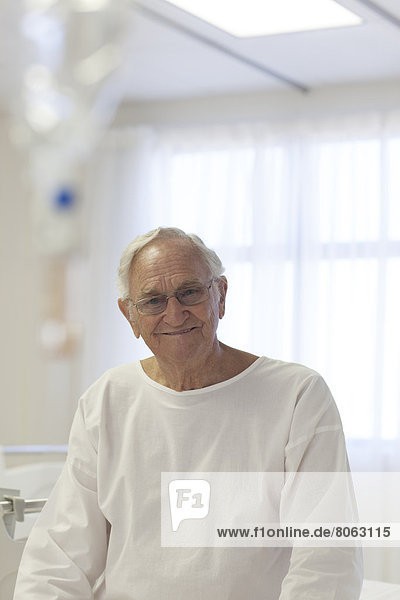 Älterer Patient lächelt im Krankenhauszimmer