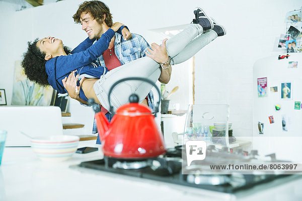 Couple playing together in kitchen
