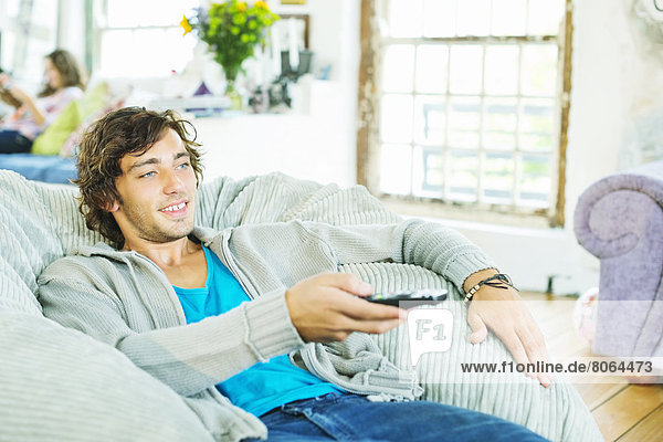 Man watching television in beanbag chair