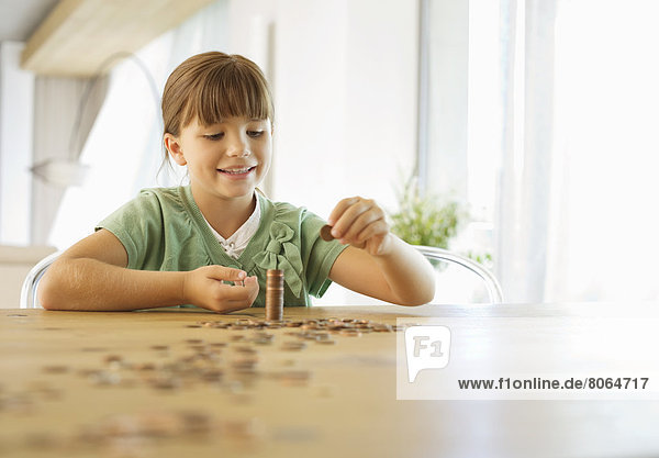 Girl stacking pennies on counter