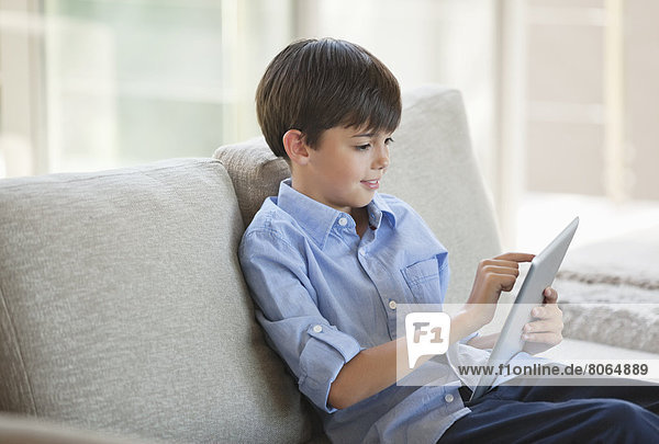 Junge mit Tablet-Computer auf dem Sofa