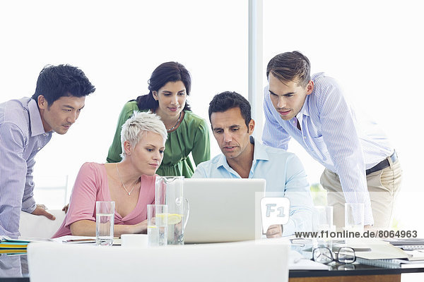 Business people using laptop in meeting
