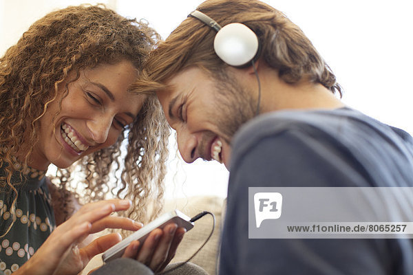 Smiling couple listening to headphones