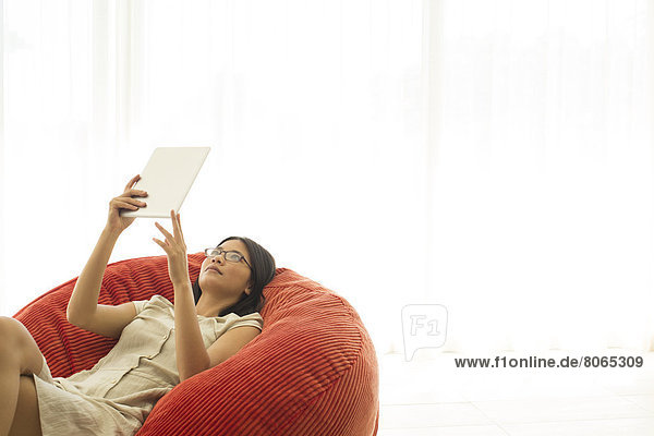 Woman using tablet computer in beanbag chair