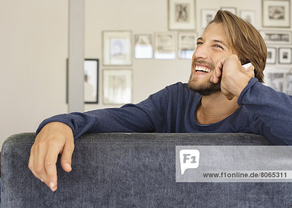 Man talking on cell phone on sofa