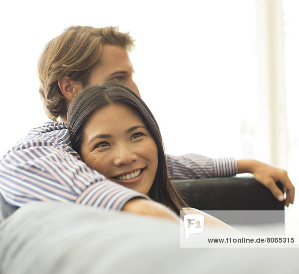 Smiling couple relaxing on sofa