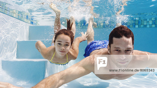 Vater und Tochter schwimmen im Pool