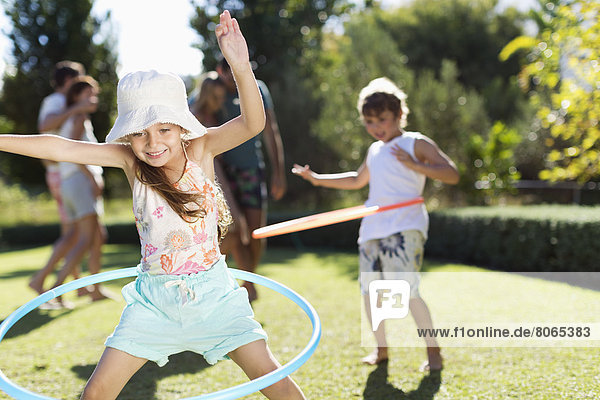 Children hula hooping in backyard