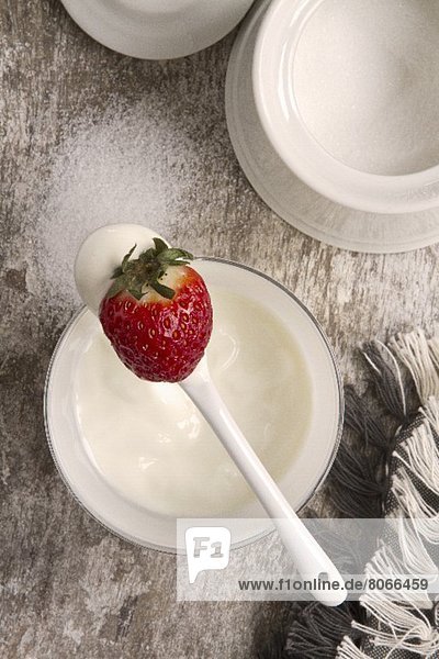 'Joghurt mit Erdbeere auf einem Löffel
