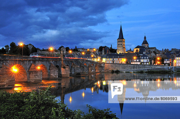 'The city of La Charite-sur-Loire on the banks of the River Loire  Nievre river  Burgundy  France  on the Way of St James  routes called ''Voie de Namur'' and ''voies du Nord''. The city lit up at night and reflections in the river'
