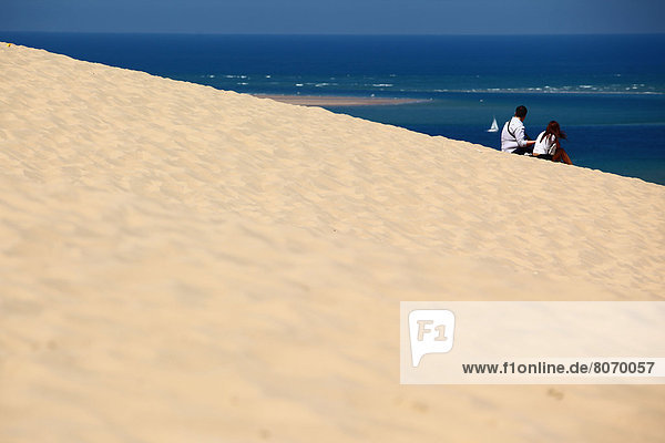 Young couple admiring the panorama and the sea from the Dune of Pyla (Gironde  Aquitaine  France)