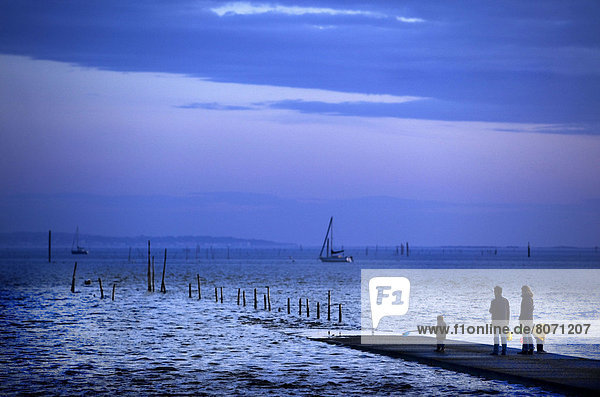 Ares (Gironde  Aquitaine  France) in the Arcachon Bay : Family at the water's edge on the pier.