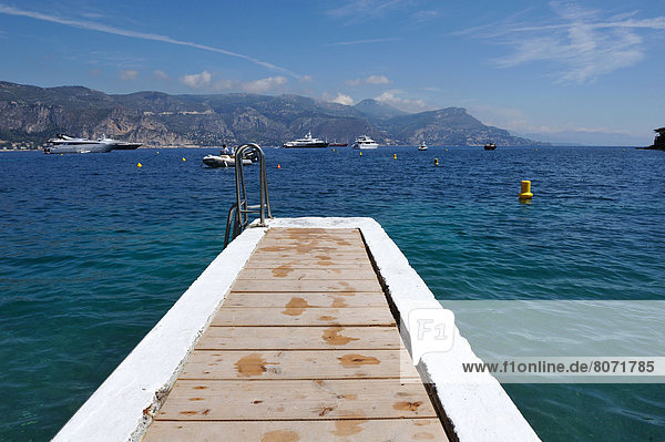 'Saint-Jean-Cap-Ferrat (06) June 2010. Landing stage of the Paloma private beach and ''Paloma Beach'' restaurant facing the bay of Beaulieu-sur-Mer. Launches and yachts lying at anchor.'