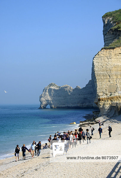 Fröhlichkeit  Strand  Steilküste  Tourist  Kieselstein  Eingang  Menschen im Hintergrund  Hintergrundperson  Hintergrundpersonen  Sonne