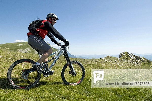 'Mountain pass ''Col du Rousset'' (26). 2011/07/04. Moutain biking with a German Bionicon variable-geometry full suspension mountain bike. Mountain biker wearing a helmet  facing the panorama on the mountains of Diois  Pre-Alps.'
