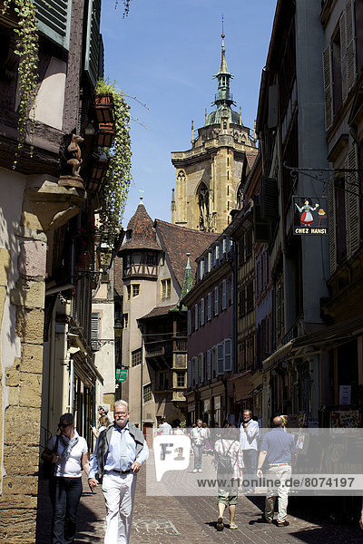 'Colmar (68). 2011/07/26. Tourists having a walk in a cobbled street of the historic centre  near the street ''rue des Marchands''. Alsatian restaurant ''Chez Hansi'' with regional specialities '