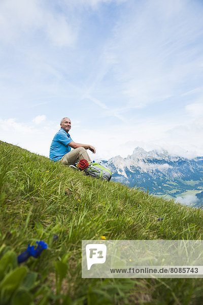 Hiker sitting on a meadow  Neunerkoepfle  Allgaeu Alps  Tannheim Valley  Tyrol  Austria  Europe