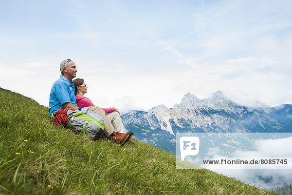 Couple sitting on a meadow  Neunerkoepfle  Allgaeu Alps  Tannheim Valley  Tyrol  Austria  Europe