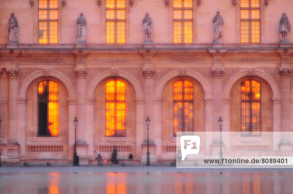 Der Louvre in der Abenddaemmerung  die untergehende Sonne beleuchtet die Fenster