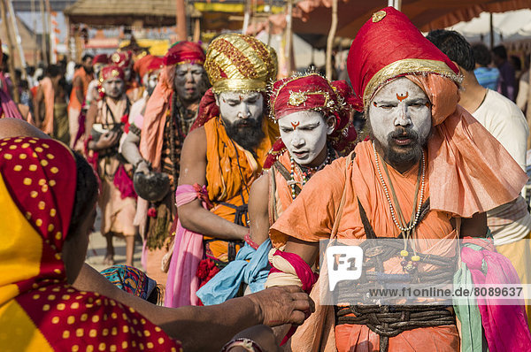 Gruppe von Gudar Sadhus  heilige Männer  zu Fuß in einer Reihe  beim Sammeln von Speisen  die von anderen Sadhus angeboten werden  am Sangam  dem Zusammenfluss von Ganges  Yamuna und Saraswati  während der Kumbh Mela