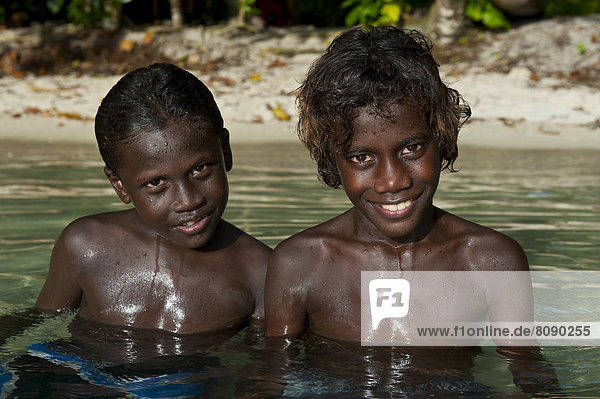 Lächelnde einheimische Jungen im Wasser der Marovo Lagune