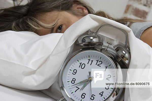 Woman in bed  alarm clock