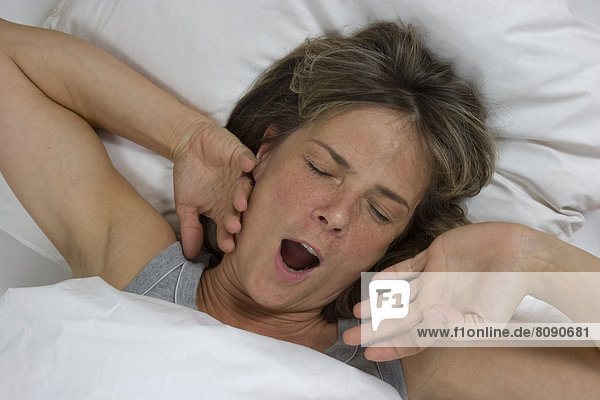 Yawning woman in bed