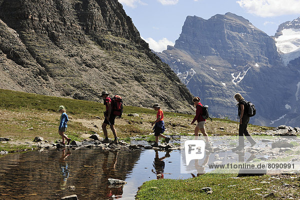 Hiker rambling in the Rocky Mountains crossing a small lake