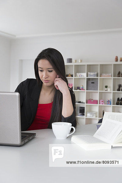 Mixed race businesswoman using laptop