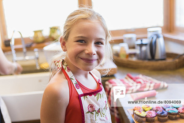 Caucasian girl smiling in kitchen