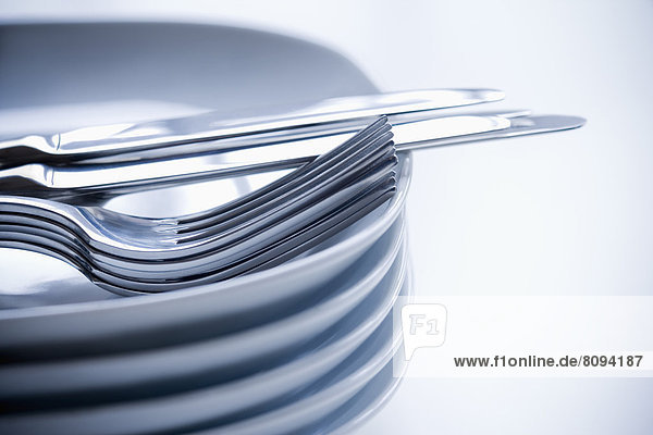 Close up of silverware and stacked plates