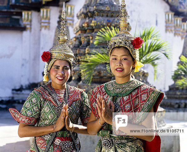 Tempeltänzerinnen im Wat Pho  Wai  thailändische Geste der Begrüßung  zwei junge Frauen in traditionellem Tanz-Kostüm