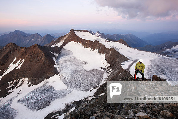 Bergsteiger steht am Gipfel des Wilden Pfaff und blickt Richtung Südtirol  Bergrat bildet die Grenze zwischen Österreich und Italien