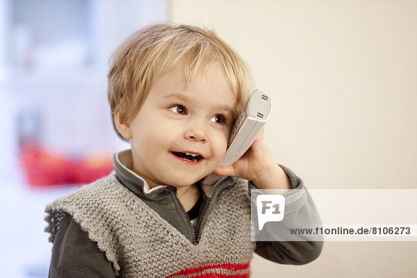 Lächelndes blondes Mädchen mit Telefon