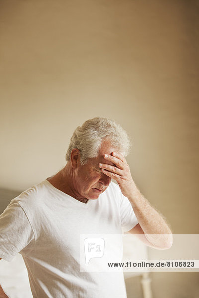 Senior man holding head in pain