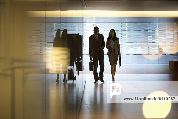 Businessman and businesswoman walking in lobby