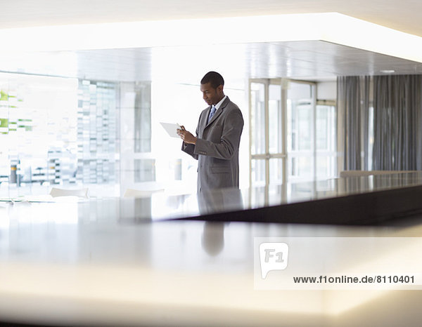 Businessman using digital tablet in lobby