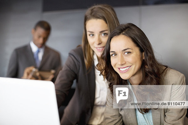 Portrait of smiling businesswomen using laptop