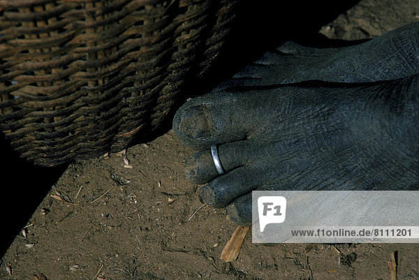Africa African Ethnicity Barefoot Basket Close-Up Color Image Culture Custom Horizontal Human Foot Jewelry Low Section Mud One Person Outdoors Part Of Photography Ring Toe Ring Tradition Traditional Tribal Lifestyle