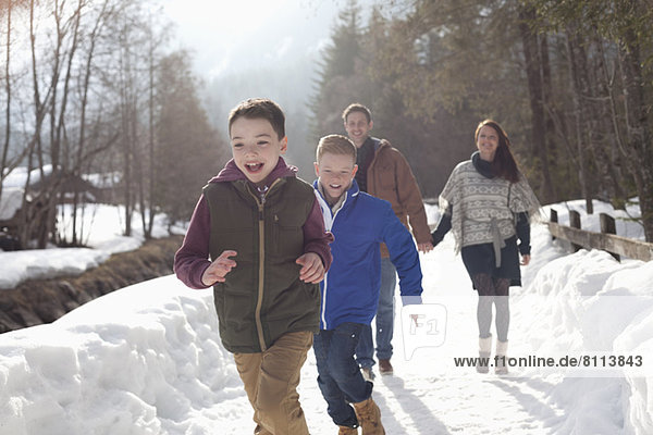 Happy family running in snowy lane