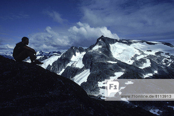 Vereinigte Staaten von Amerika USA hoch oben Außenaufnahme sitzend Einzelperson eine Person Berg Farbaufnahme Farbe Tag sehen Wolke Ruhe Silhouette Himmel Hügel Einsamkeit Querformat rauh Fotografie Seitenansicht Freundlichkeit nur ein Mann Alaska freie Natur Hang Schnee