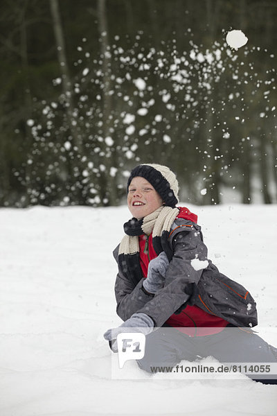 Portrait of happy boy enjoying snowball fight