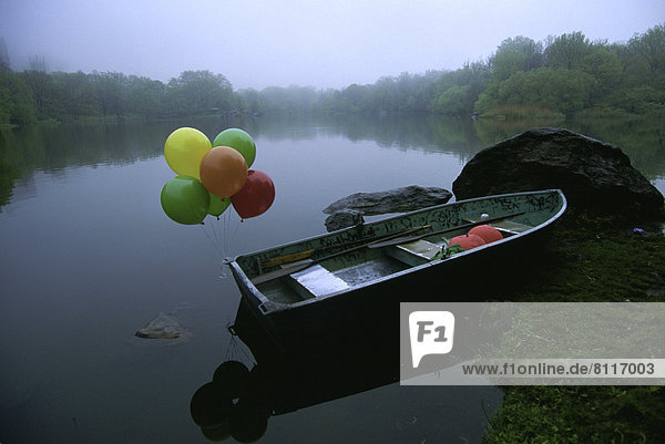 North America USA New York City Sky Trees Water Lake Reflection Grass Stones Balloons Colorful Boat One Boat Decorated Nobody Still Nature Peaceful Placid Pleasant Solitude Tranquil Docked Waterways Transportation Outdoors Day Side View Horizontal Color Image Photography