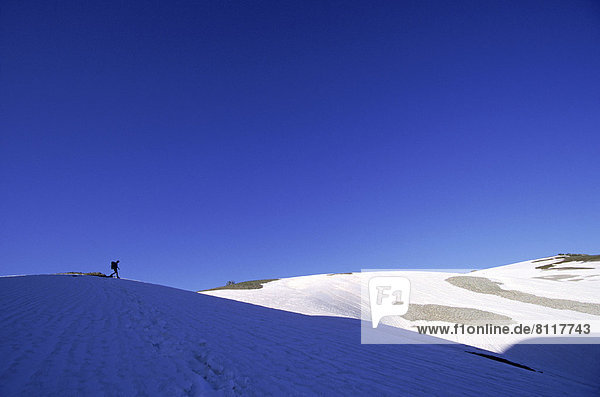 North America USA Wyoming Grand Teton Sky Snow Mountains Trail Shadow One Person Walking Crossing Nature Adventure Zest Enthusiasm Calm Vast Peaceful Outdoors Day Distant Horizontal Color Image Photography