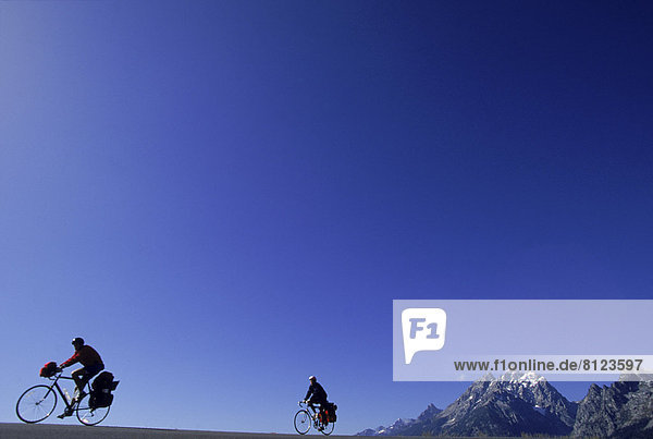Bike Bicycle Color Image Copy Space Cycling Grand Teton National Park Horizontal Mountain Mountain Peak Outdoors Photography Transport Travel Two People Unrecognizable Person USA Wyoming Leisure Activity Sports Transportation Travel Destinations