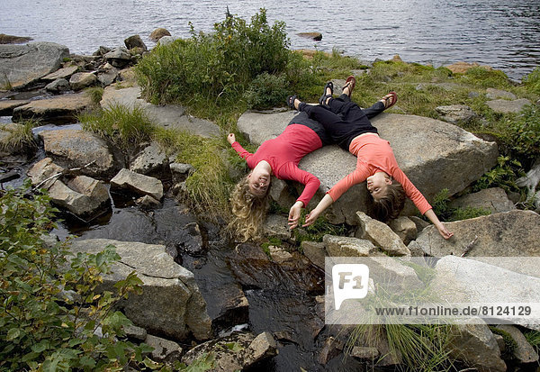 two girls sisters hiking nature forest beauty wilderness lying rocks playing friendship horizontal outdoors daytime color image photography