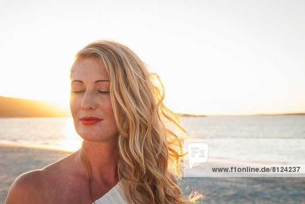 Blonde Frau mit geschlossenen Augen am Strand bei Dämmerung  Kapstadt  Südafrika