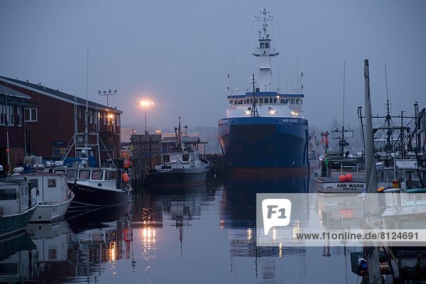 horizontal color image outdoors day morning daybreak dawn sunrise fog nobody large group of objects harbor dock boat ship vessel transportation port water ocean sea quiet calm still reflection blue gray